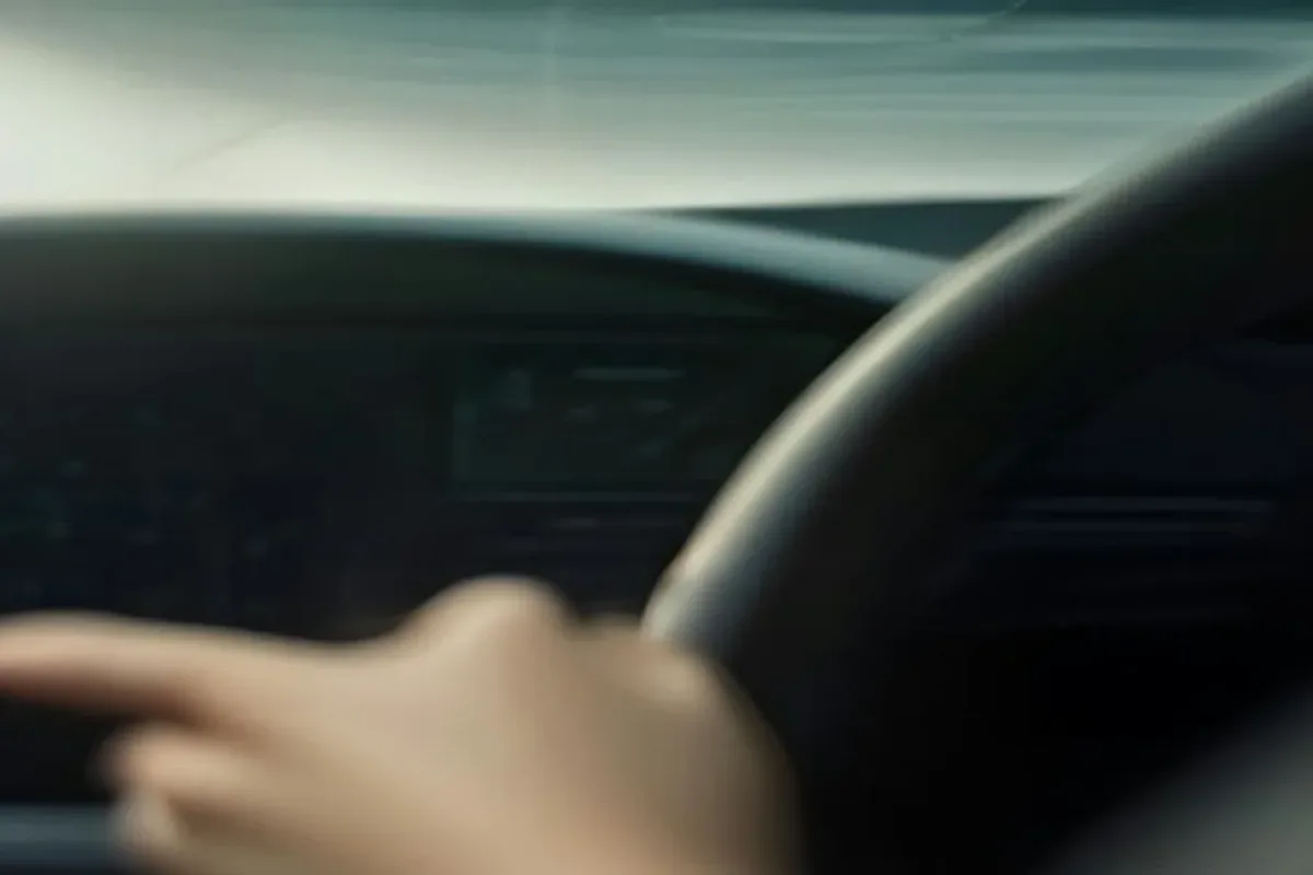 Driver with hands on the wheel while adaptive cruise control is active
